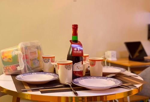 a table with plates and a bottle of wine at Pandora's Nest in Manila