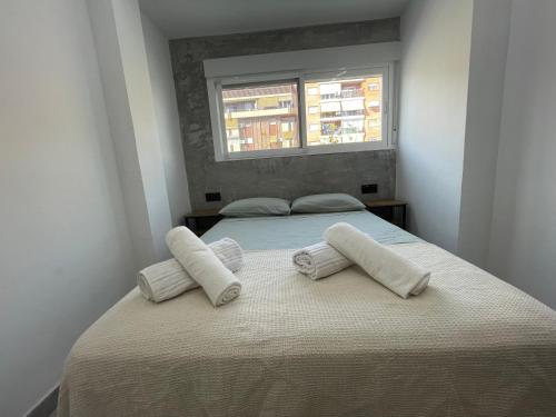 sypialnia z łóżkiem z dwiema poduszkami i oknem w obiekcie Benidorm JL 1 y 2 w mieście Benidorm