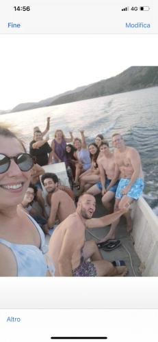 a group of people sitting in a boat in the water at Camping Lisna in Vau i Dejës