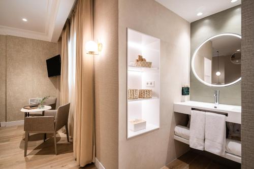 a bathroom with a sink and a mirror at Melia Plaza Valencia in Valencia