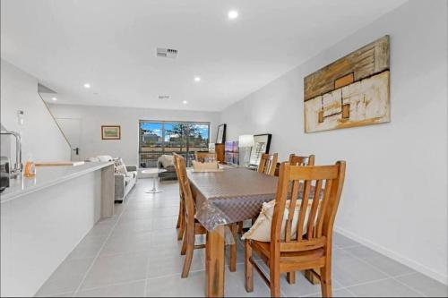 a kitchen and dining room with a table and chairs at Brand New Home In Oran Park in Narellan