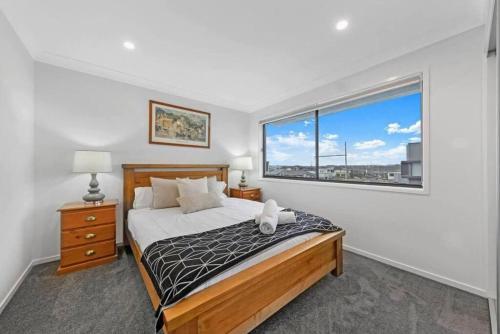 1 dormitorio con cama y ventana grande en Brand New Home In Oran Park, en Narellan