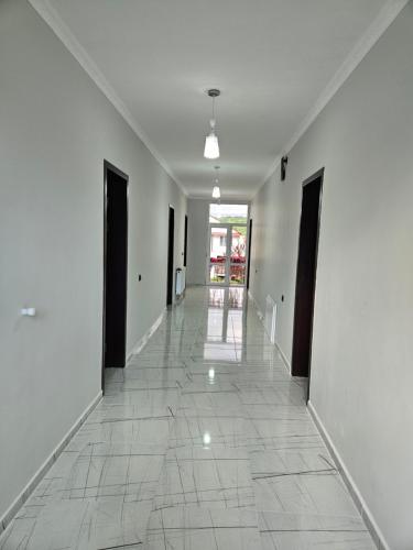 an empty hallway with white walls and a tile floor at Urban hotel Tsalenjikha in Tsalenjikha