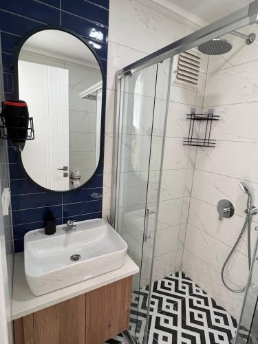 a bathroom with a sink and a shower with a mirror at Flamingo - stylish apartments near the beach, in the heart of Alanya in Alanya