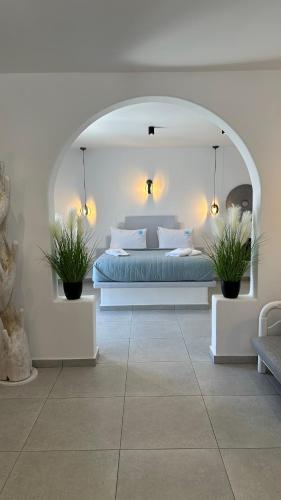 a bedroom with a bed and two potted plants at Miracles Suites by Anastasia Princess, Adults Only in Perissa