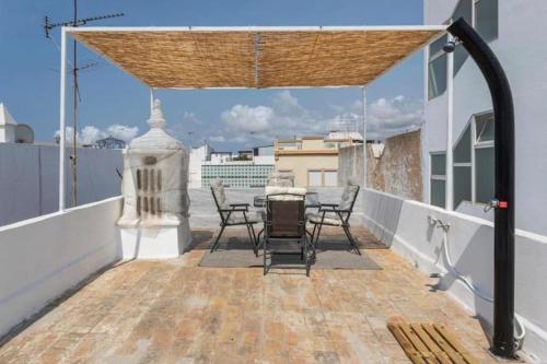 a balcony with a table and chairs on a roof at Floripes Stylish in Olhão
