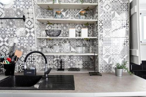 a kitchen with a sink and a tile wall at Floripes Stylish in Olhão