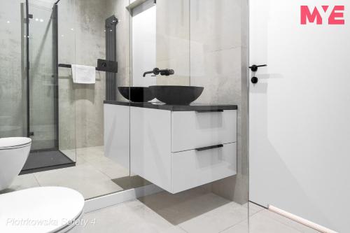 a bathroom with a sink and a toilet at MYE Apartments - Piotrkowska 44 in Łódź