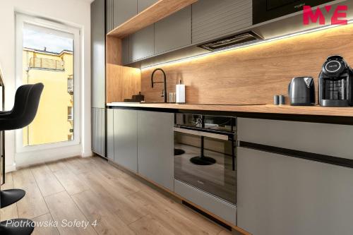 a kitchen with black cabinets and a counter at MYE Apartments - Piotrkowska 44 in Łódź