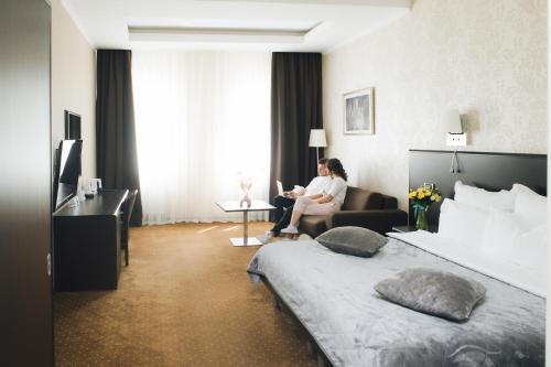 eine Frau auf einem Stuhl in einem Hotelzimmer in der Unterkunft Alexandrovskiy Hotel in Odessa