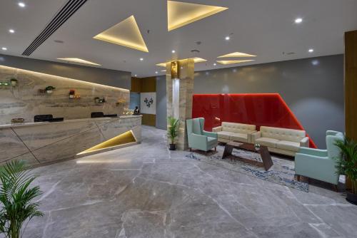 a lobby with a waiting room with a couch and chairs at Grand Continent Hosur A Sarovar Portico Affiliate Hotel in Hosūr