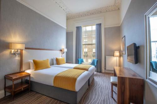 um quarto de hotel com uma cama e uma janela em Albany House em Dublin