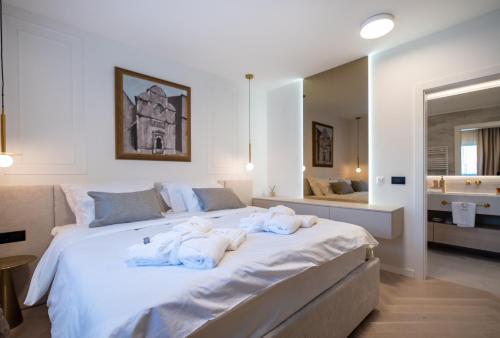 a bedroom with a large white bed with towels on it at Cascade Luxury Apartments in Dubrovnik