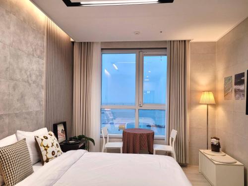 um quarto de hotel com uma cama e uma grande janela em Elliy's Room em Busan