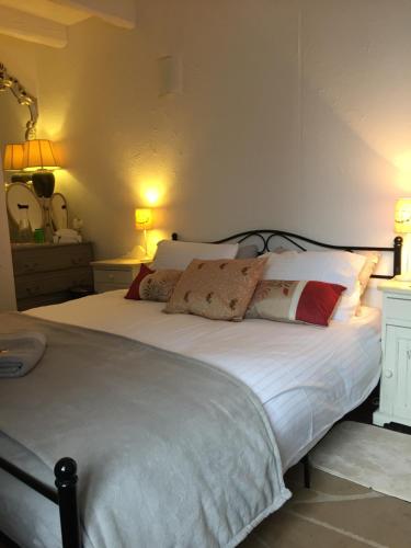 sypialnia z dużym łóżkiem z białą pościelą i poduszkami w obiekcie La Grande Maison Seglien w mieście Séglien