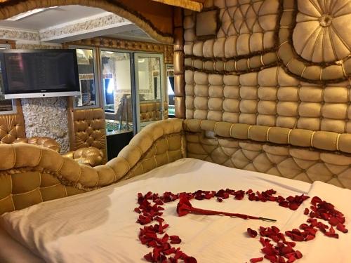 Habitación con cama con pétalos de rosa rojo. en Bali Colosseum Hotel en Belgrado