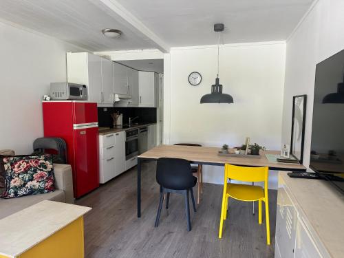uma cozinha com uma mesa e 2 cadeiras e um frigorífico vermelho em Sentrumsvegen - Private Studio Apartment in Gol em Gol