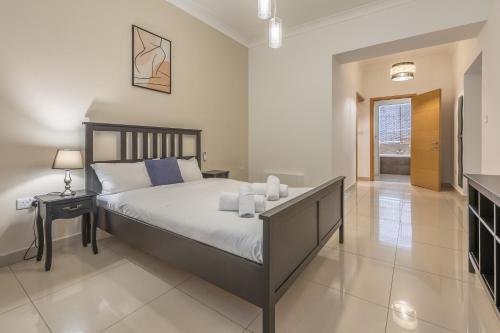 a bedroom with a bed and a table with candles on it at Hard to come by - modern & huge house in Sliema in Sliema