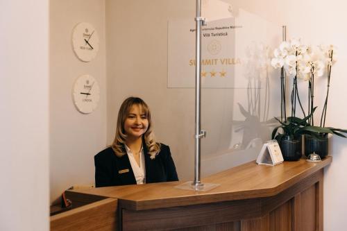 a woman sitting at a counter in a room at Summit Villa in Chişinău