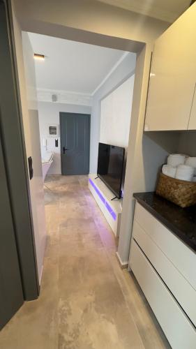 a living room with a television and a kitchen at George luxury living in Preveza