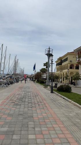 a cobblestone walkway next to a harbor with boats at George luxury living in Preveza