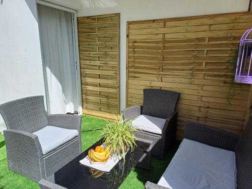 a patio with wicker chairs and a table with a plant at Apartments Sun & Sea in Dugi Rat