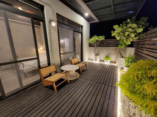 eine Terrasse mit 2 Stühlen und einem Tisch auf dem Balkon in der Unterkunft The Retro Tai-Pan in Tainan