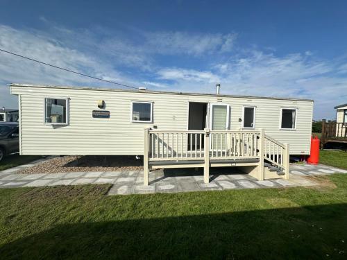 a white mobile home with a porch and a deck at Kingfisher 1004 Keyshare holiday lets 8 Berth in Ingoldmells