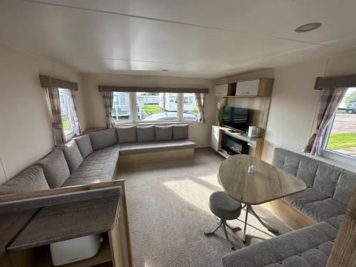 a living room with a couch and a table at Kingfisher 1004 Keyshare holiday lets 8 Berth in Ingoldmells