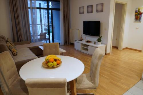 Belgrade Waterfront Comfortable Apartment في بلغراد: غرفة معيشة مع طاولة مع وعاء من الفواكه عليها