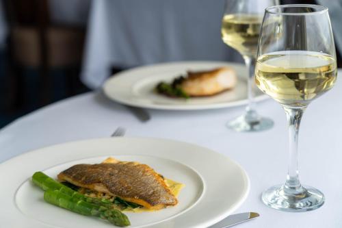 a table with two plates of food and a glass of wine at Redcastle Hotel in Moville