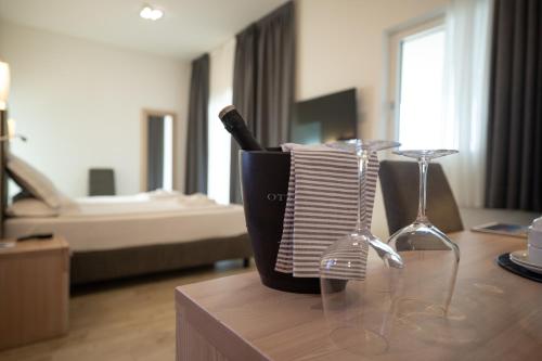 a bottle of wine and glasses on a table at Hotel Bellariva in Riva del Garda