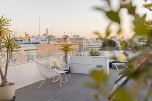 a balcony with chairs and a view of a city at Candelaria10 in Cádiz