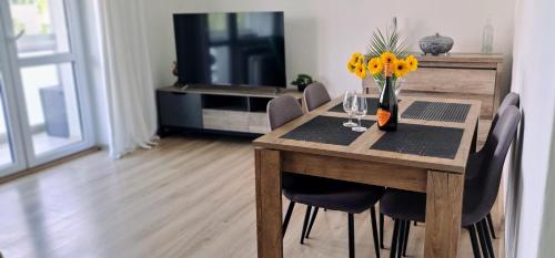 uma mesa de jantar com cadeiras e um vaso de flores em Lovely furnished 1 bedroom flat with balcony in Ostrava em Hrabŭvka