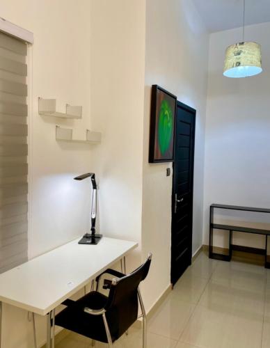 a desk with a lamp and a chair in a room at LUXURYs apartment in Abomey-Calavi