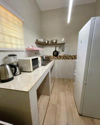 a kitchen with a counter and a white refrigerator at LUXURYs apartment in Abomey-Calavi