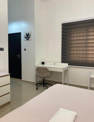 a white room with a desk and a window at LUXURYs apartment in Abomey-Calavi