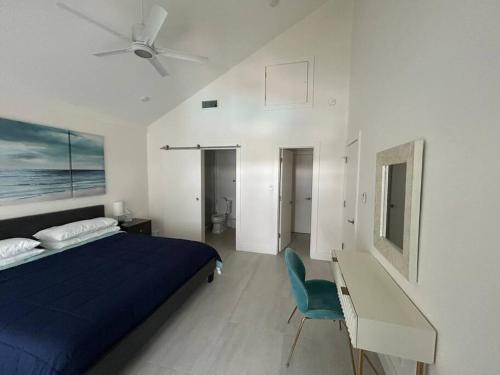 a bedroom with a bed and a desk and a ceiling fan at Sunset Cove - Condo 314 in George Town