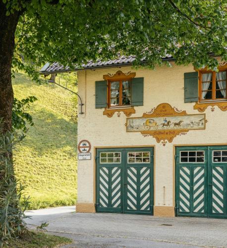 a building with two green garage doors and a tree at Haus Herzogstand - Ferienwohnungen in Kochel am See in Kochel