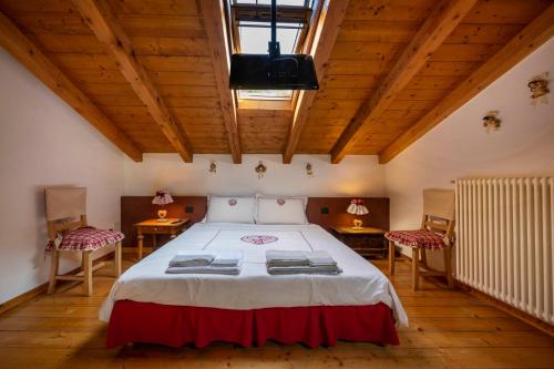 a bedroom with a bed with two tables and two chairs at LA TANA DEL GRILLO in Feltre