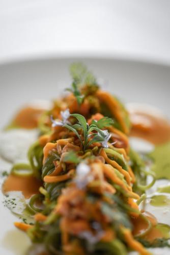 a plate of food with carrots and green vegetables at Locanda MaMaGiò in Valdobbiadene