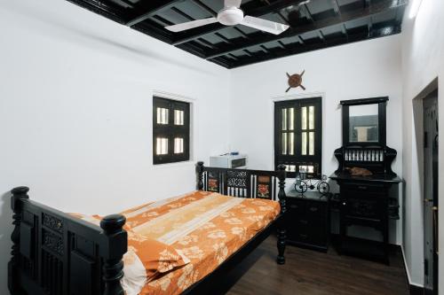 a bedroom with a bed and a ceiling fan at Ashriel Farm House by EWA Properties in Kankanādi