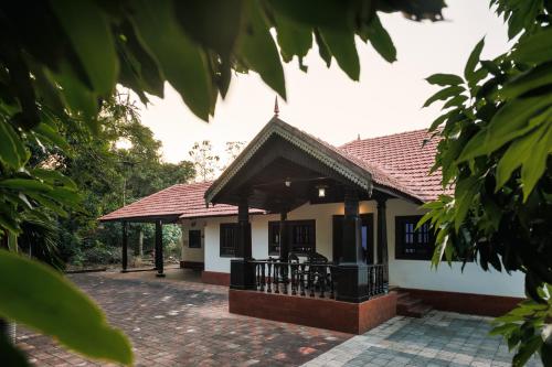 a small house with a roof at Ashriel Farm House by EWA Properties in Kankanādi
