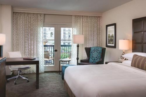 a hotel room with a bed and a desk and a balcony at Gaylord Texan Resort and Convention Center in Grapevine