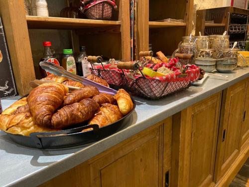 a buffet with bread and pastries on a table at Hôtel La Muette in Arles