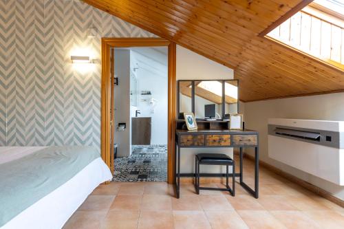 Hotel Conde De Badaran في Badarán: غرفة نوم مع سرير ومكتب مع مرآة