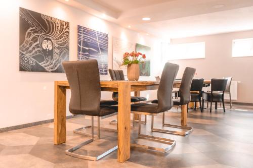 - une salle à manger avec une table et des chaises en bois dans l'établissement Remstal Hotel, à Weinstadt
