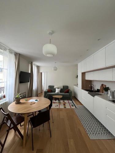 un salon avec une table et une cuisine dans l'établissement One bedroom Temple - CityCosy, à Paris
