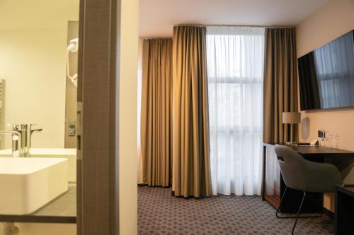 Cette chambre comprend une salle de bains pourvue d'une baignoire et d'un lavabo. dans l'établissement Remstal Hotel, à Weinstadt