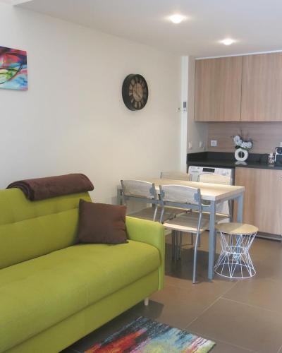 un salon avec un canapé vert et une table dans l'établissement Mini Loft Daval, à Paris